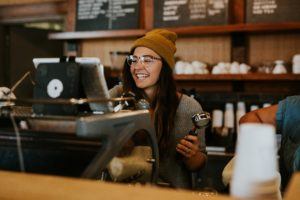 customer relationship management - employee at coffee shop smiling