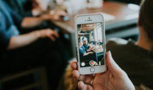 content strategy - person taking video of team meeting on iphone