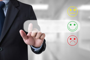 Web Design - Man choosing happy or sad graphics for survey review