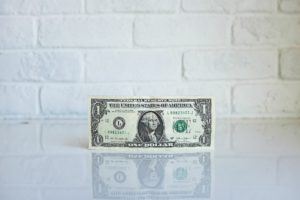 marketing budget - dollar bill in front of white brick wall