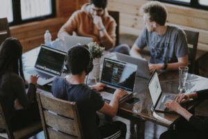 company culture - team working at community table in office