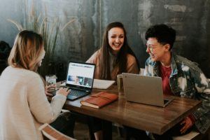 company culture - team sitting around table laughing and smiling